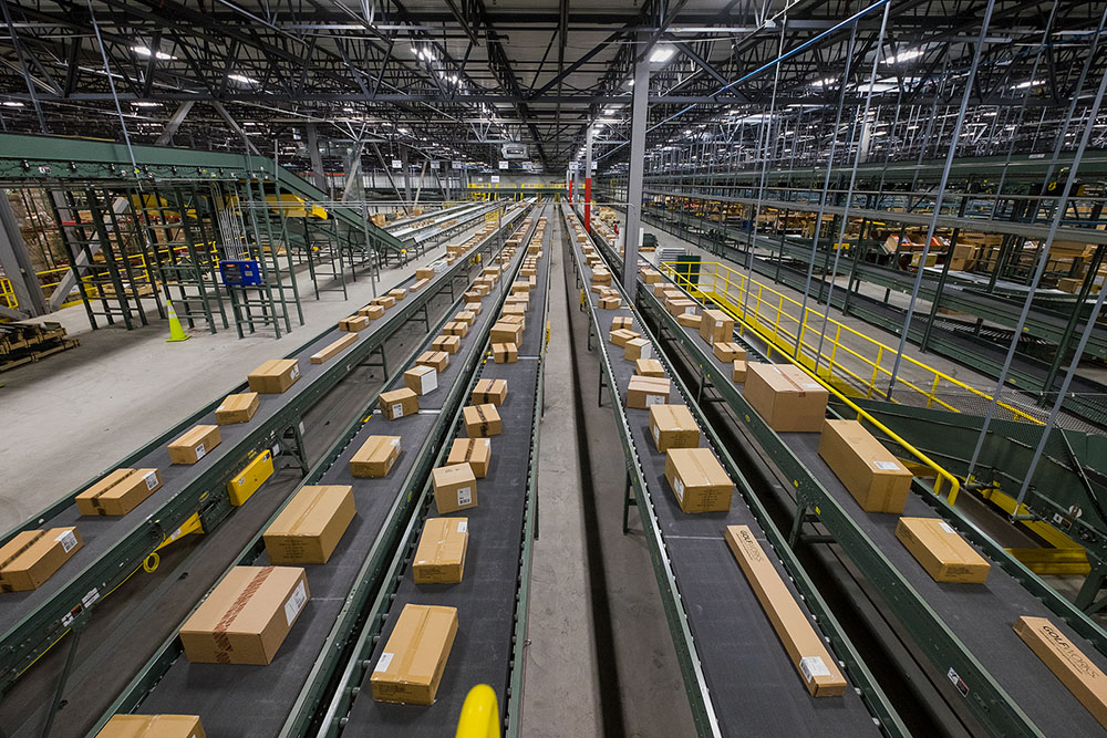 Conveyor belt through distribution facility