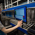 Decathlon microfulfillment case study -  retail worker using touchscreen at goods to person workstation