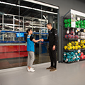 Bastian Solutions engineer shaking hands with Decathlon retail worker in front of microfulfillment system